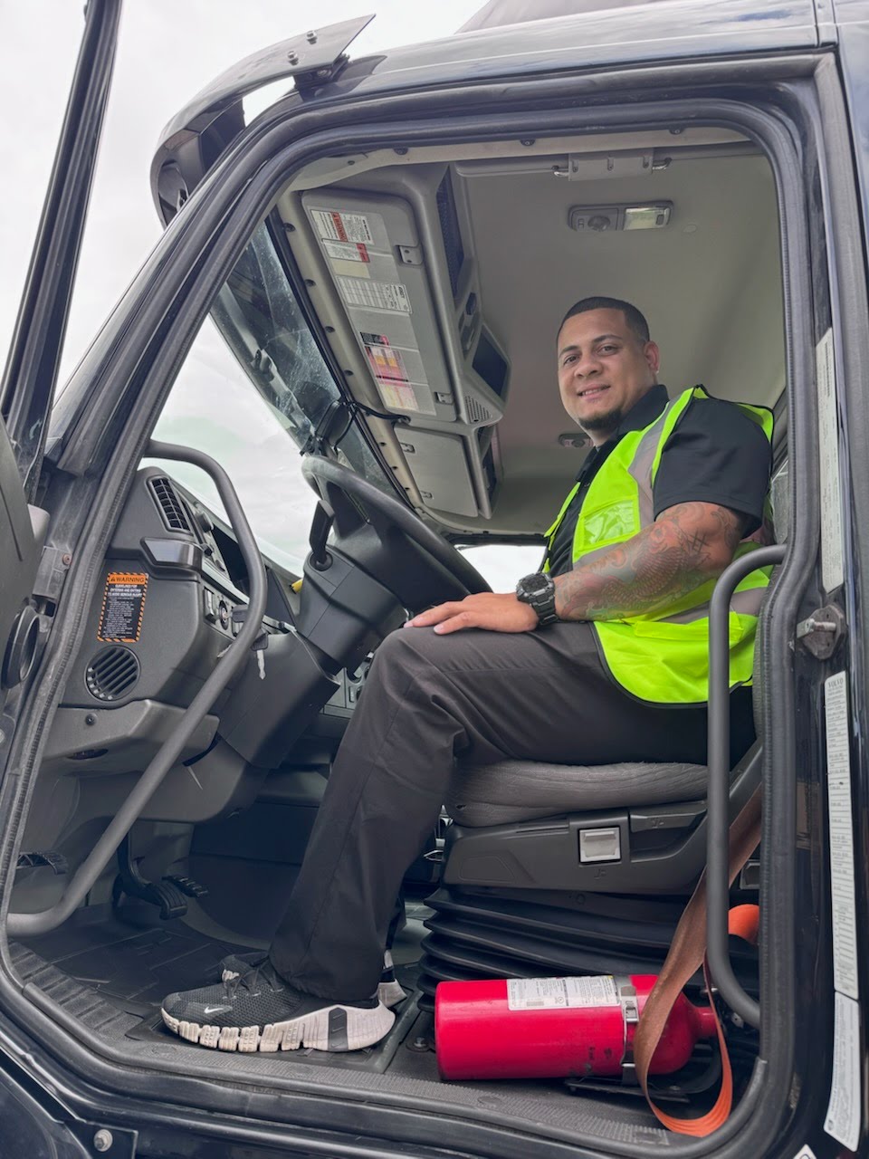 Victor Melendez sits in the cab of a tractor-trailer.