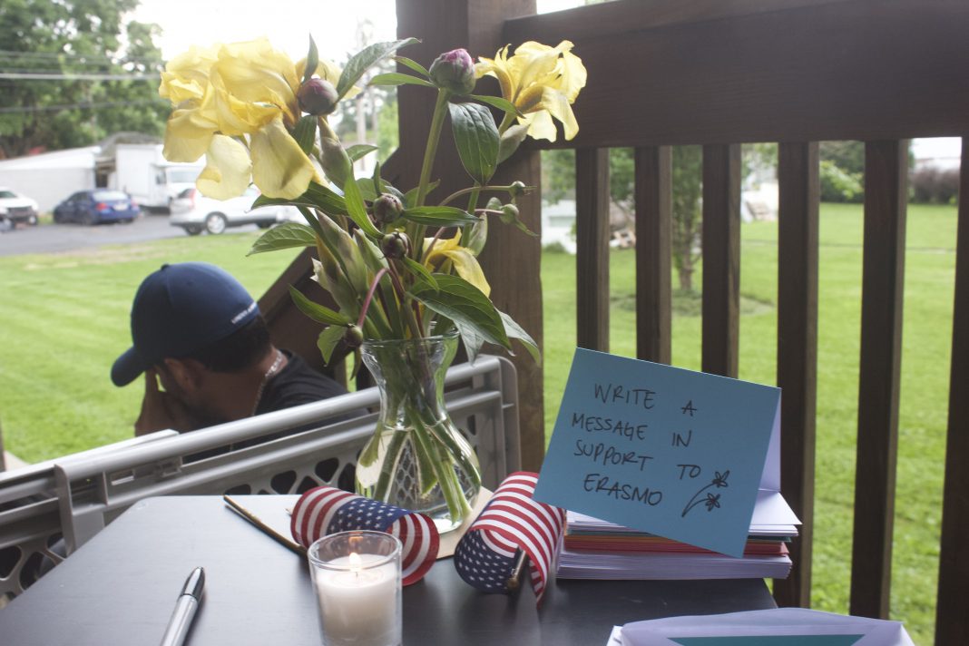 Flowers and a small American flag on a table at a vigil in Muhlenberg Township, where supporters were invited to write messages to Erasmo Zavala. He is being held at Moshannon Valley Processing Center.